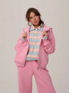 Détail du sweat à capuche rose brodé et pantalon large assorti avec polo à rayures