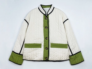 Detail of diamond quilted texture and green contrast trim on white winter jacket