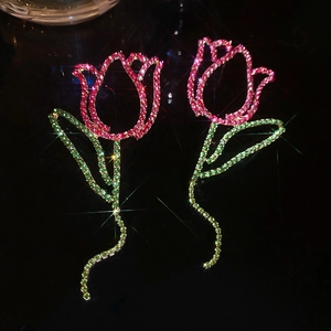 Detail of tulip earrings with red and green rhinestones and a sparkling star effect