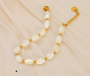 Detailed macro of stainless steel chain with white pearls and gold lobster clasp
