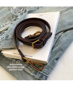 Detail of adjustable dark brown leather shoulder strap with gold metal lobster clasp