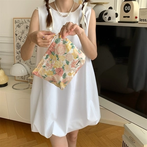 Floral cotton cosmetic bag being held by a model in a cozy lifestyle setting