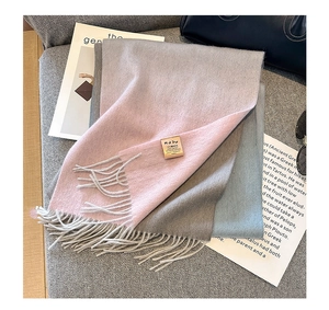 Close-up of pure cashmere wool scarf texture with fringe details and woven brand label