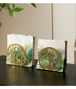 Detailed view of gold tree and deer hollow patterns on metal napkin holders