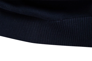 Close-up of dark navy V-neck sweater showing high-density ribbed knit cuffs and hem detail