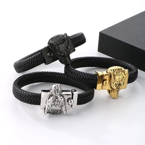 Three men's woven leather bracelets with vintage wolf head metal clasps in black, gold, and silver