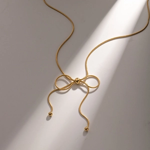 Minimalist gold butterfly pendant necklace with sleek snake chain and metallic bead accents