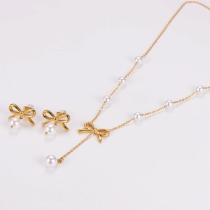 Detailed view of the gold bow jewelry set featuring white imitation pearls and necklace