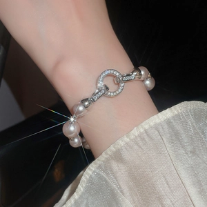 Gros plan d'un bracelet en perles avec fermoir rond serti de zircons sur soie