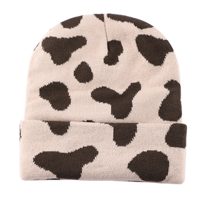 Close-up of the fine knit texture and stylish cow print pattern on this winter beanie