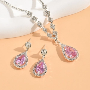 Macro view of silver necklace and earrings set with pink pear-shaped cubic zirconia