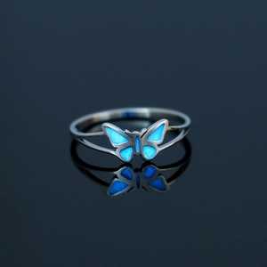 Luminous blue butterfly ring in stainless steel with reflection on dark background