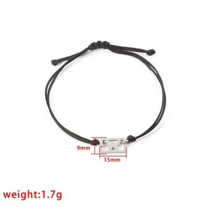 Minimalist black braided bracelet with silver butterfly hollow charm on white background