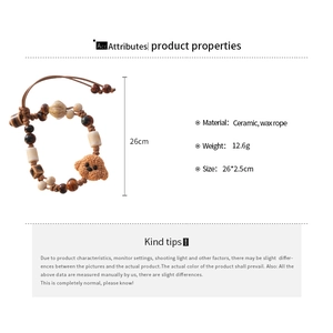 Detail of handmade ceramic teddy bear charm bracelet with brown wax rope and beads