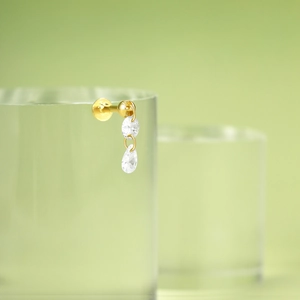 Macro shot of gold-plated star stud earring with clear crystal fringe on a stand