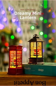 Close-up of lighted Christmas lanterns with Santa Claus inside a red phone booth and black lamp