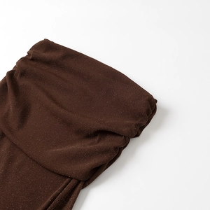 Detailed close-up of dark brown knit fabric with sparkling metallic glitter textures
