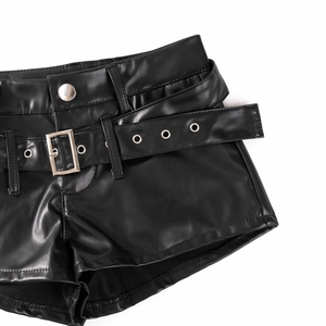 Detail von schwarzen PU-Ledershorts mit Gürtel, silbernen Metallschnallen und Metallösen