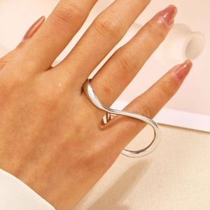 Dettaglio di un anello a due dita in argento minimalista stile infinito sulla mano