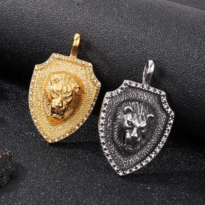 Detail of lion head shield pendants in gold and silver with crystal rhinestones