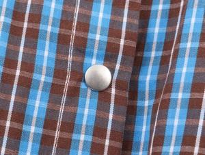Dettaglio macro del tessuto a quadri blu con chiusura a bottone a pressione in metallo