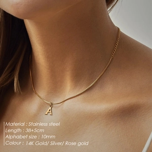 Minimalist stainless steel necklace with gold letter A pendant worn by elegant model
