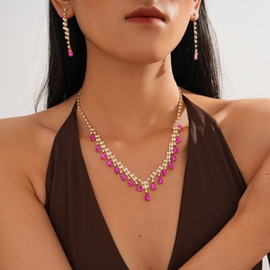 Luxury gold necklace and earring set with pink teardrop stones and shimmering tassels