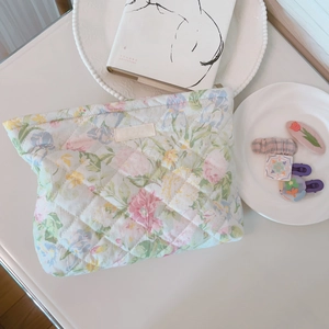 Macro detail of floral quilted fabric texture and Simple Wish label on cosmetic bag