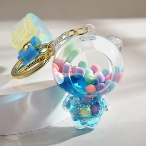 Detail of transparent bear keychain featuring blue liquid, glitter, and colorful beads