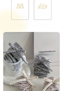 Detail view of cotton socks with satin bows and 3D textures in soft neutral colors