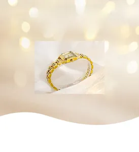 Detail of elegant gold square watch with roman numerals on soft white fabric