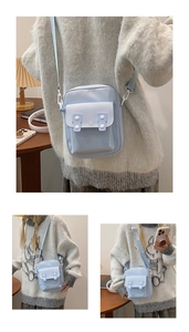Detail of light blue canvas crossbody bag with adjustable strap and front flap pocket