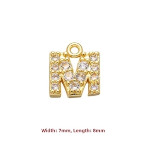 Macro detail of gold-plated letter M pendant with cubic zirconia inlay 7x8mm