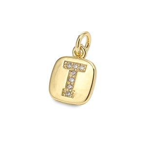 Macro shot of gold square letter T pendant with zircon inlays and round metal link