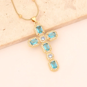 Detail of 18K gold cross necklace featuring blue rectangular stones and white zircons