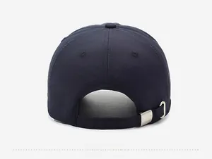 Detail of adjustable metal buckle with logo on a navy blue breathable baseball cap