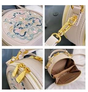 Detail view of ethnic beige round bag with floral embroidery and gold-tone hardware