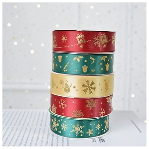 Close-up of assorted Christmas satin ribbons with gold snowflake and tree prints