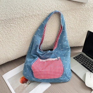 Close-up of a blue denim tote bag with red gingham pocket and white lace details