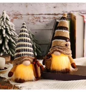 Close-up of lighted Christmas gnomes with warm LED glow on a cozy wooden background