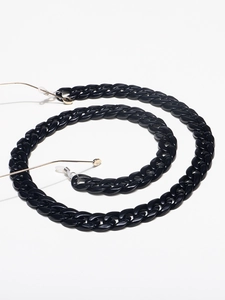 Close-up of black resin Cuban link eyewear chain with gold clips and silicone loops