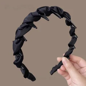 Detail of black fabric headband with integrated hair clips for multi-style hair styling