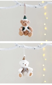Detail of plush Christmas bears in brown and white hanging on white branches