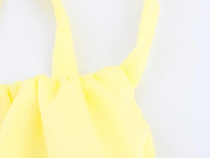 Detailed close-up of stitching and twill fabric texture on yellow halter neck top