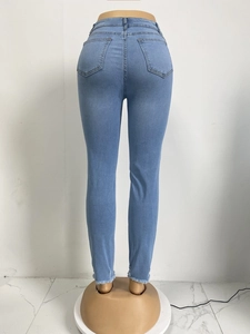 Detail einer hellblauen Slim-Fit-Jeans mit fransigen Säumen an einer Schneiderpuppe