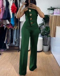 Detail of dark green strapless jumpsuit featuring decorative gold buttons and wide legs