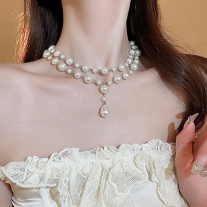 Close-up of double-layer white pearl necklace with water drop pendant on a model