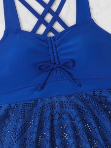 Detail of royal blue tankini top featuring crochet lace hem and drawstring bow front