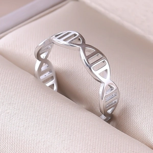 Detail of silver DNA helix ring on a beige satin jewelry box at a 45-degree angle