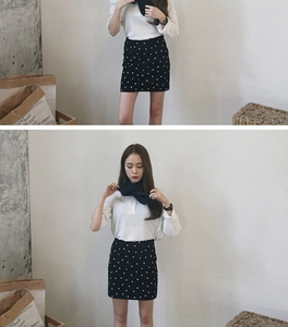 Detail shot of navy blue knitted short scarf with a stylish black polka dot mini skirt